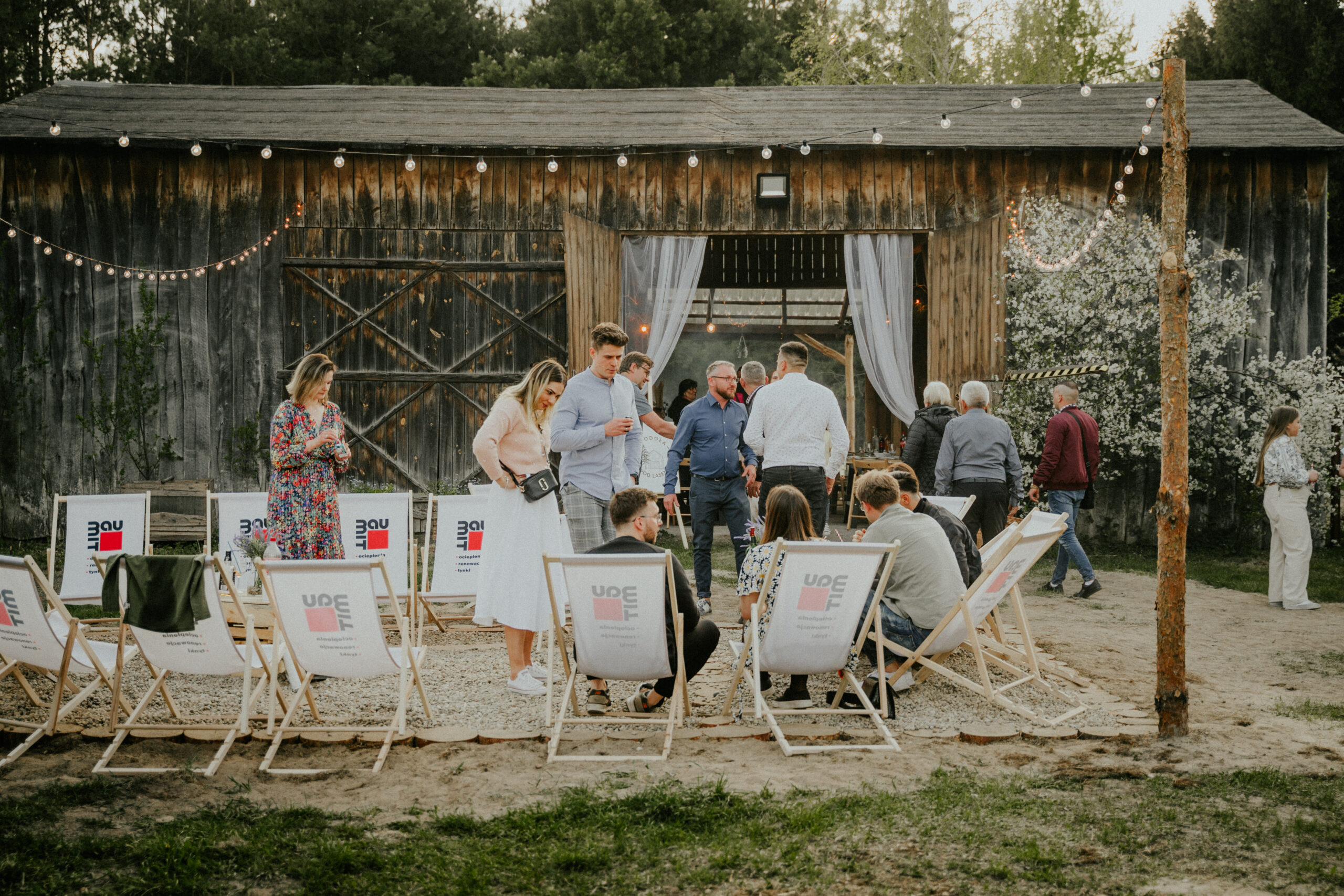 Goście odpoczywają przed stodołą podczas wesela w stylu slow – miejsce do odpoczynku podczas wesela