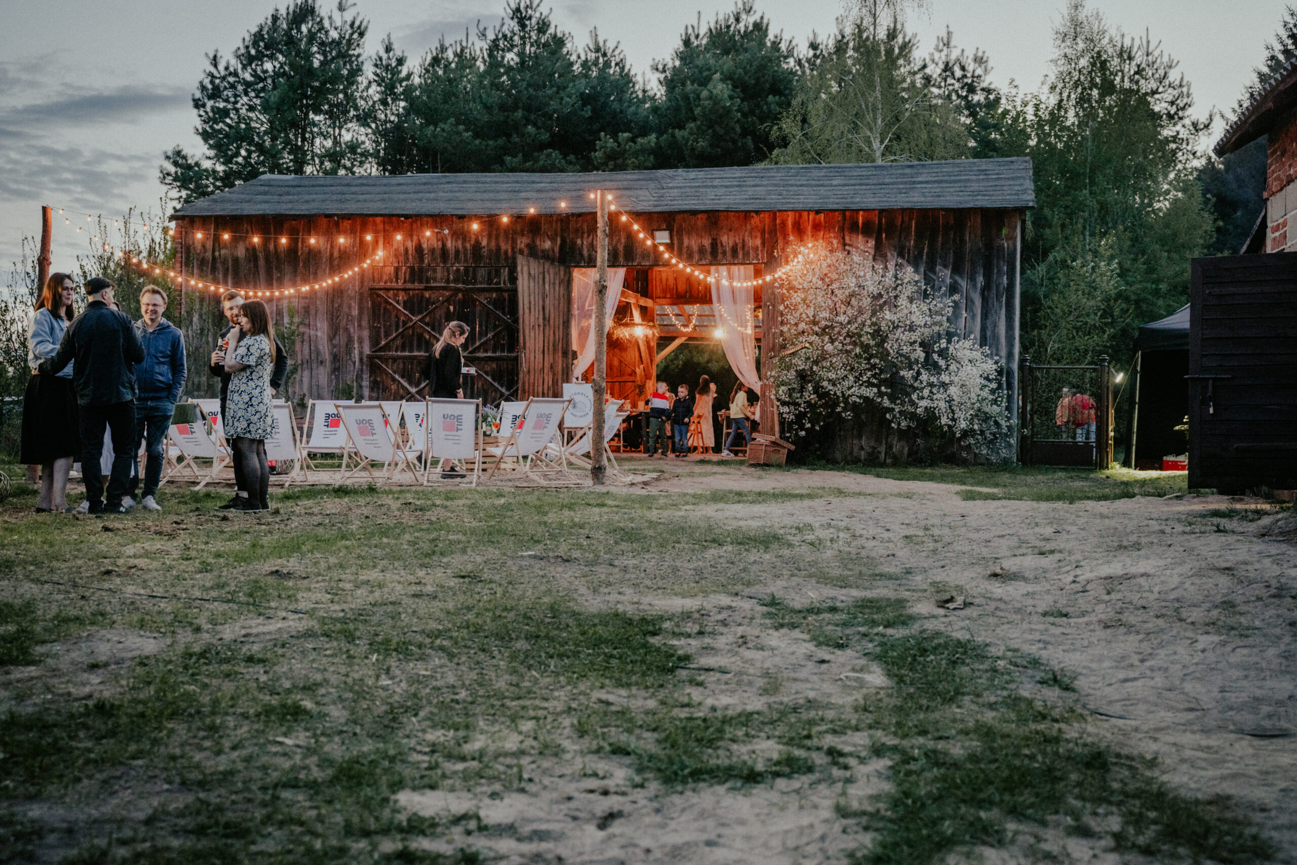 Widok na stodołę z podwórka o zmroku – oświetlenie stodoły podczas imprezy w stylu slow